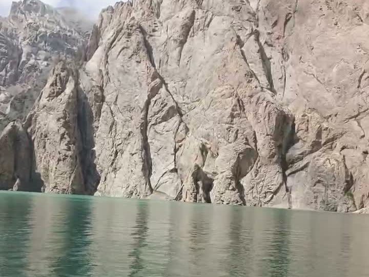 Turquoise Kel-Suu lake between steep rock walls